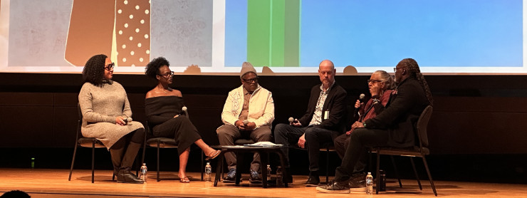 Six faculty and alums sit on the stage during a panel discussion.